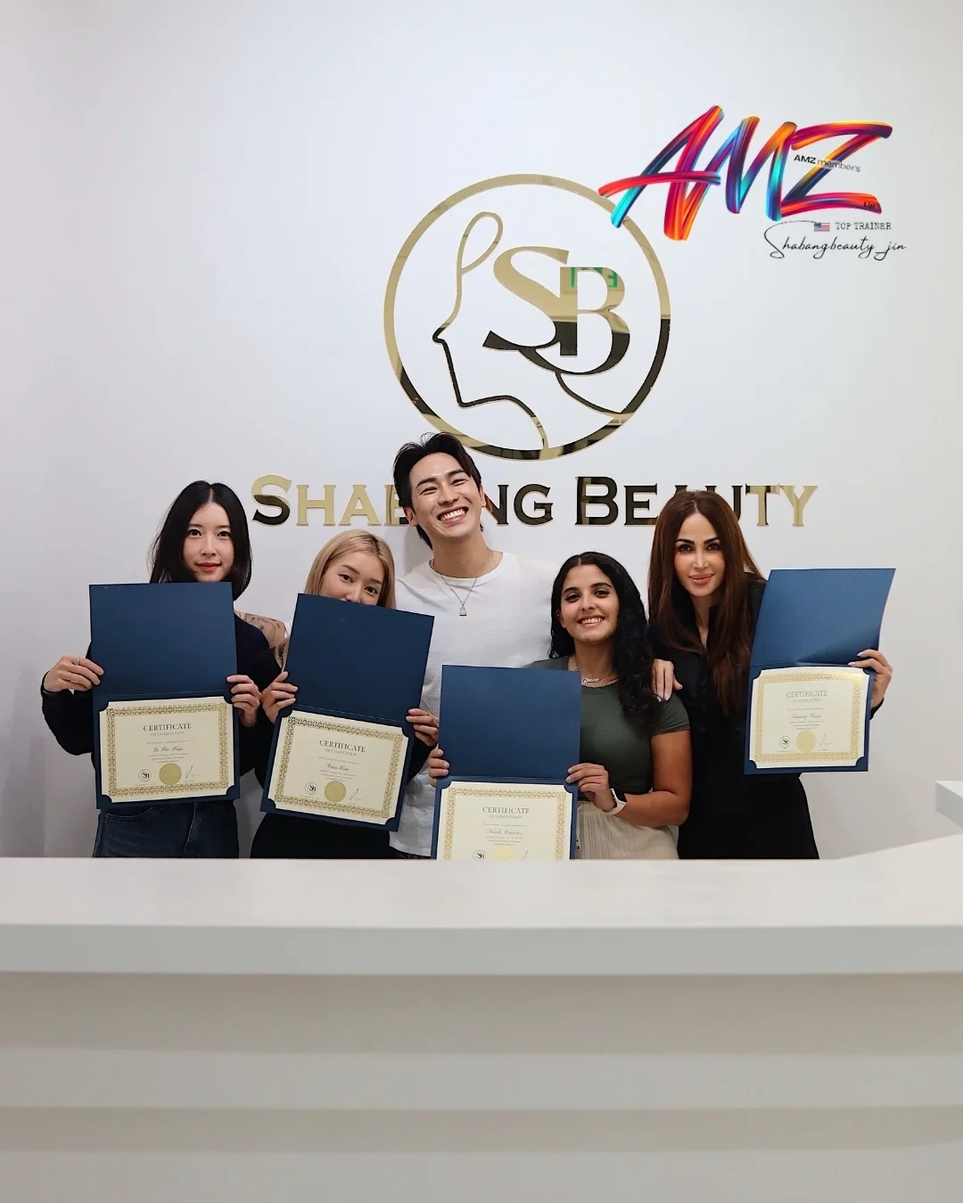 Academy graduates holding certificates at Shabang Beauty